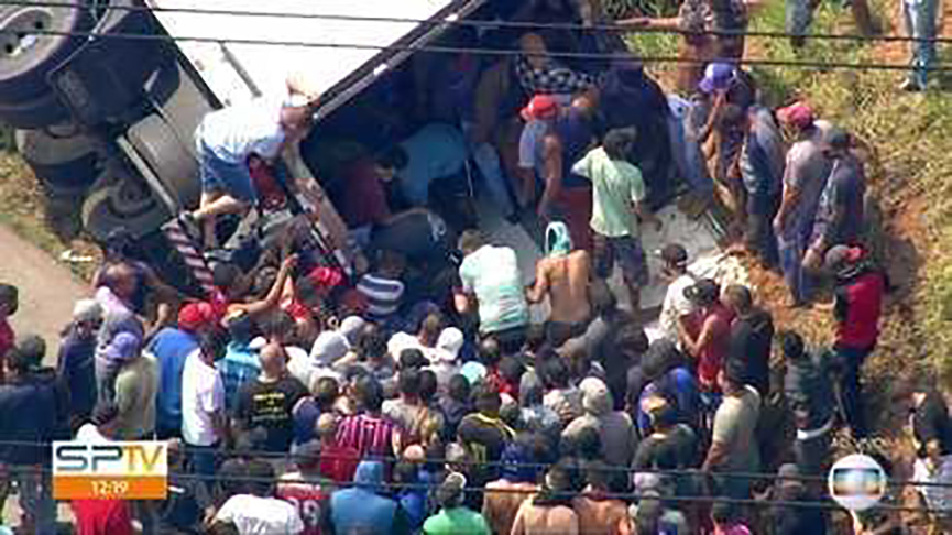 Carreta que tombou com carga de carne é saqueada. (Foto: Reprodução/TV Globo)