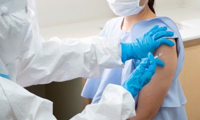 médico aplicando vacina em braço de mulher
