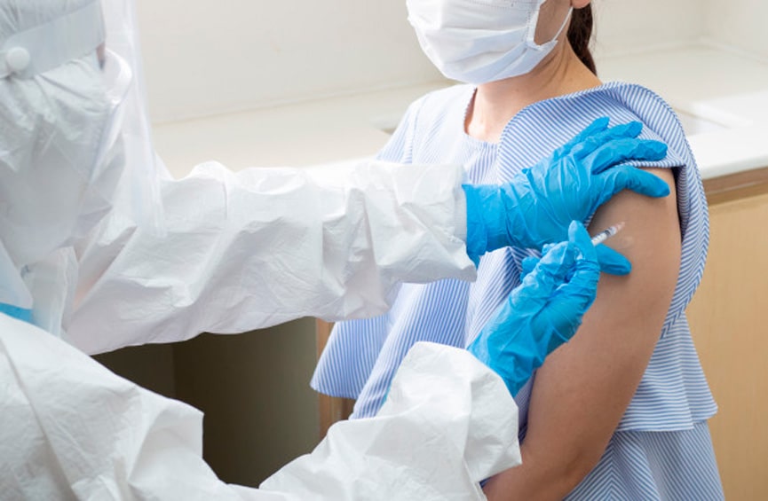 médico aplicando vacina em braço de mulher