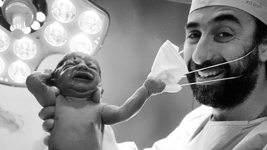 Bebê puxa máscara de médico após o parto