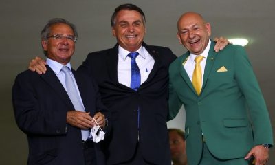 O empresário Luciano Hang, o presidente Jair Bolsonaro e o ministro da Economia, Paulo Guedes, durante o lançamento do programa Voo Simples, no Palácio do Planalto.