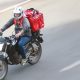 Motoboy pilotando moto com mochila de entrega