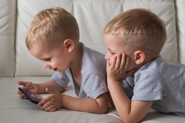 Duas crianças usando um smartphone