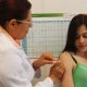 Profissional da saúde aplicando vacina em mulher