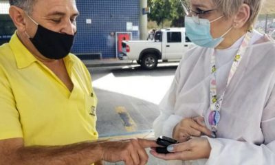 Profissional da saúde afere temperatura de cidadão em terminal de Jundiaí