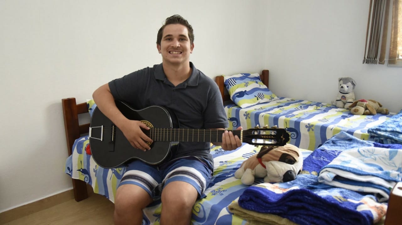 Enquanto sonha com a carreira musical, Jair dos Santos, um dos primeiros acolhidos, aproveita para ensaiar com seu violão novo.