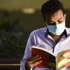 Homem usando máscara lendo um livro