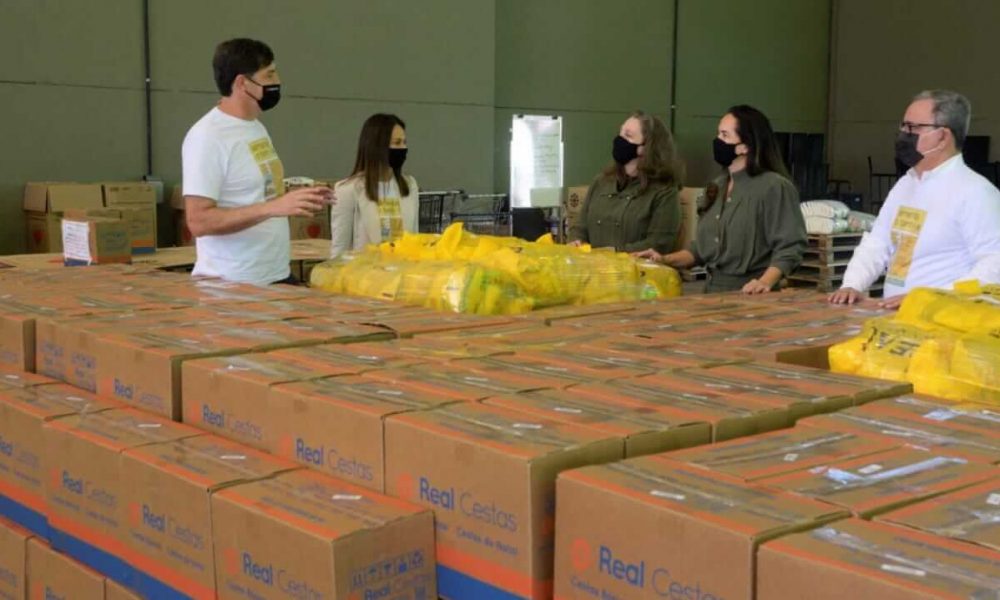 Pessoas em meio a caixas básicas de alimentos no Fundo Social de Solidariedade de Jundiaí