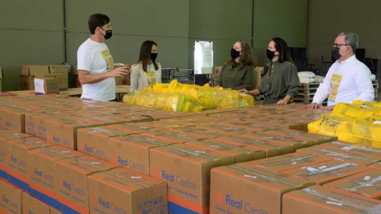 Pessoas em meio a caixas básicas de alimentos no Fundo Social de Solidariedade de Jundiaí