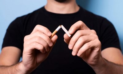 Homem partindo cigarro ao meio