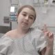 Menina sentada em leito de hospital