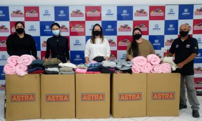 Funcionários do Grupo Astra com caixas de doação de roupas para o Funss