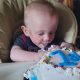 Bebê em frente a bolo de aniversário