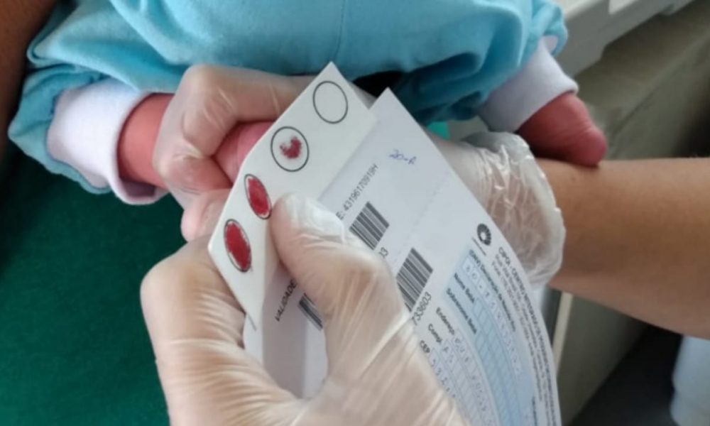 Médica fazendo teste do pezinho em recém-nascido