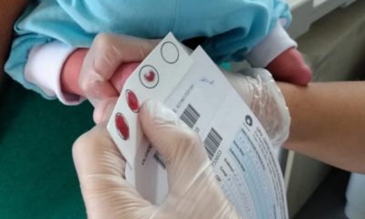 Médica fazendo teste do pezinho em recém-nascido