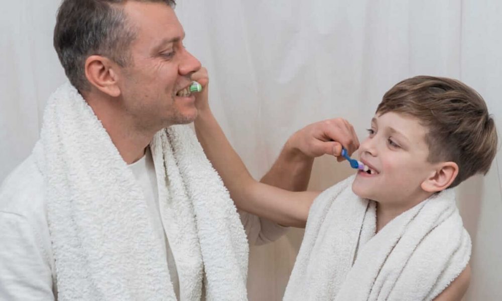 Pai e filho escovando os dentes