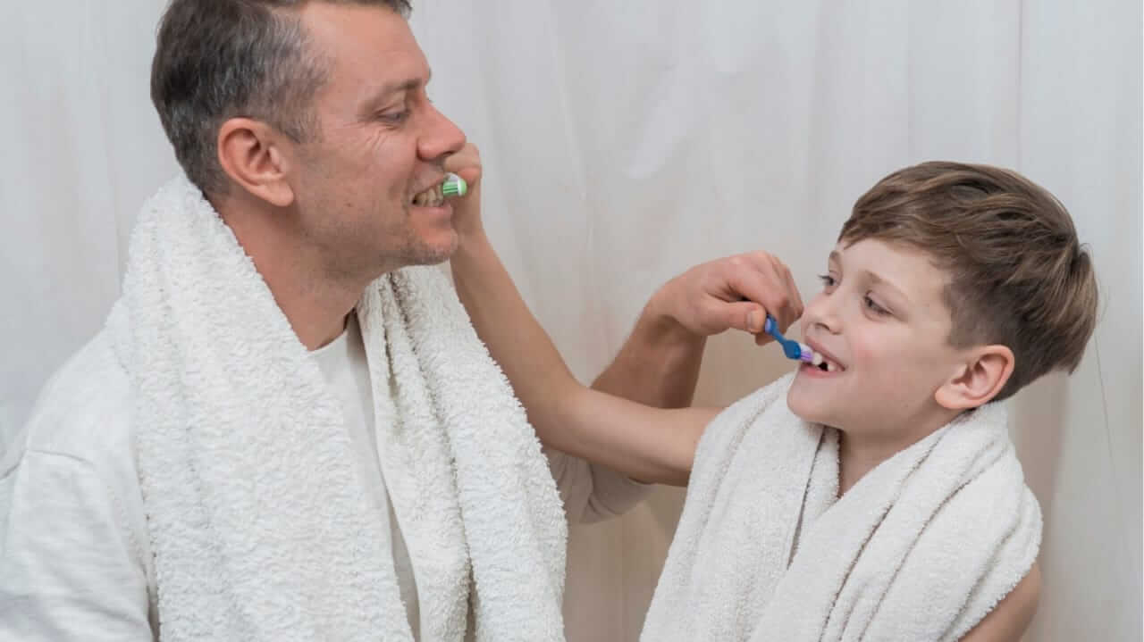 Pai e filho escovando os dentes