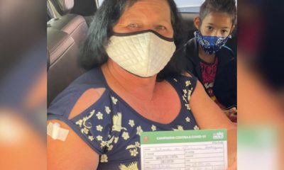 Mulher com cartão de vacinação contra Covid19
