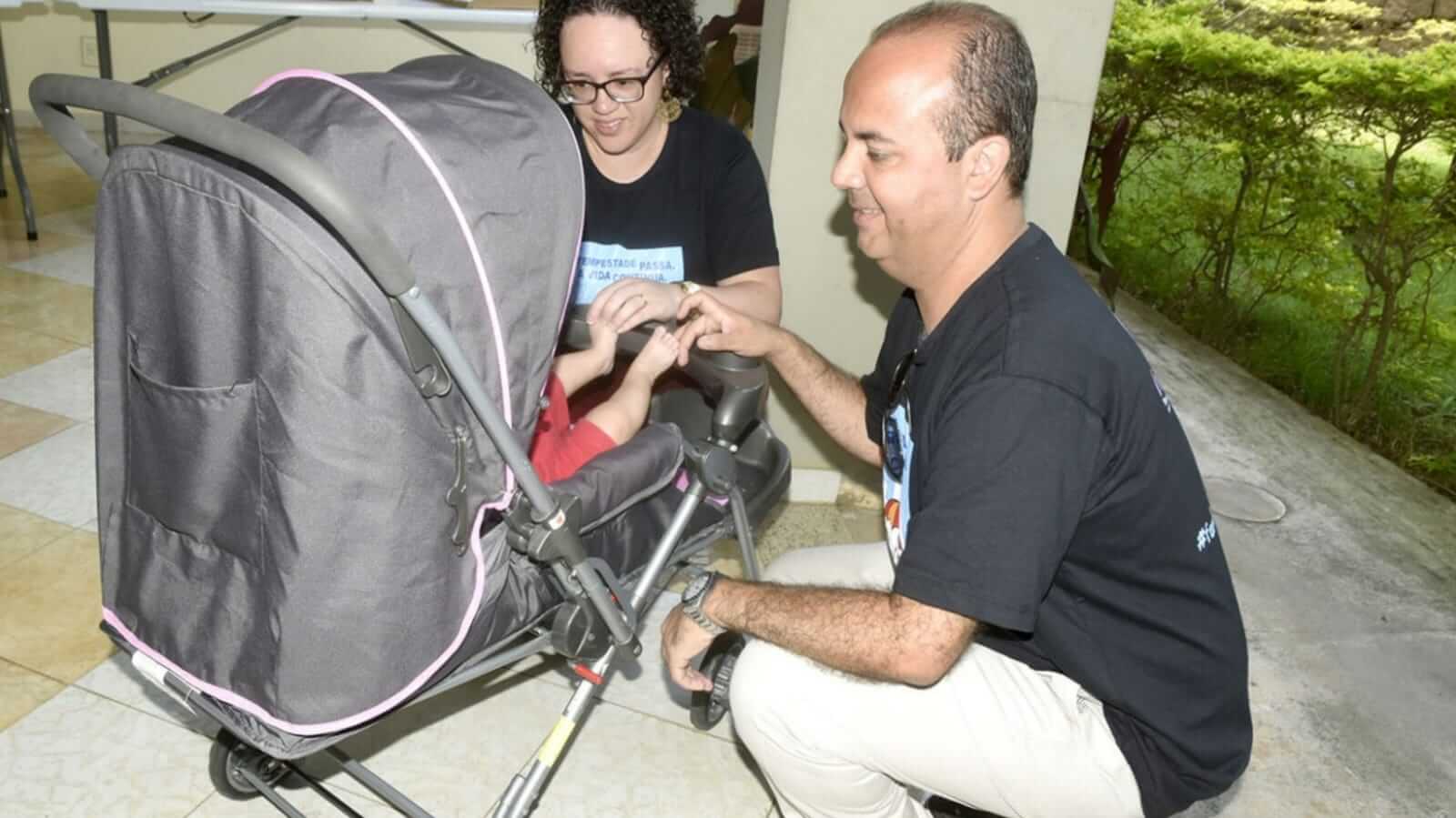 Homem e mulher em frente a carrinho de bebê