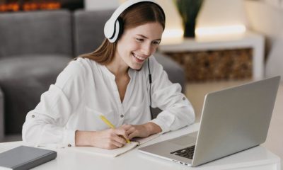 Mulher com caderno em frente à computador