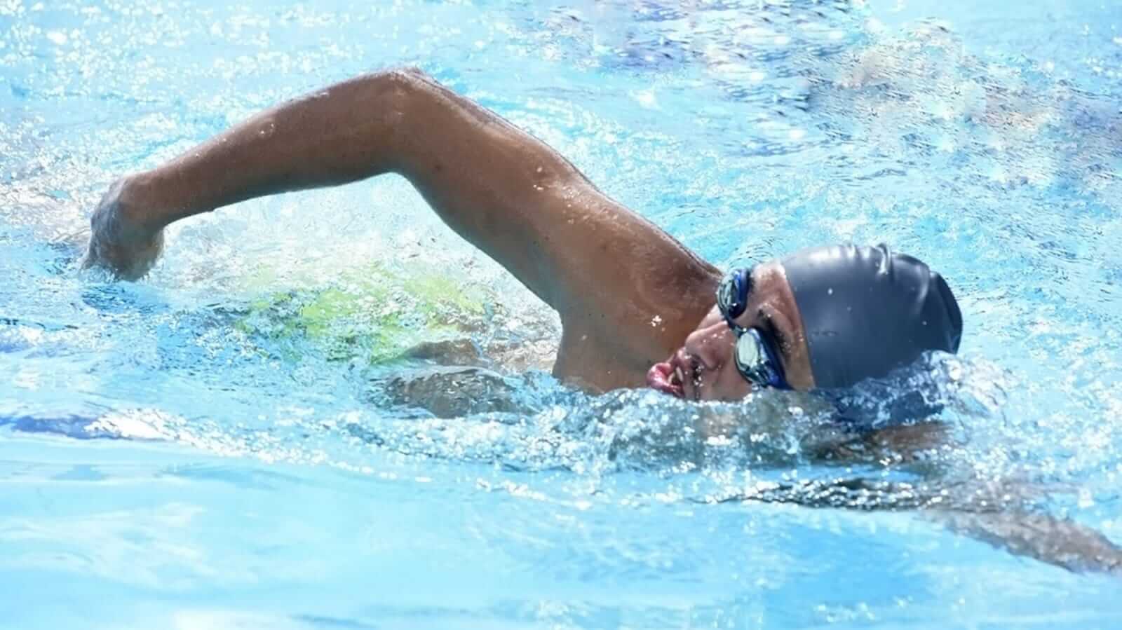 Homem treinando natação em piscina