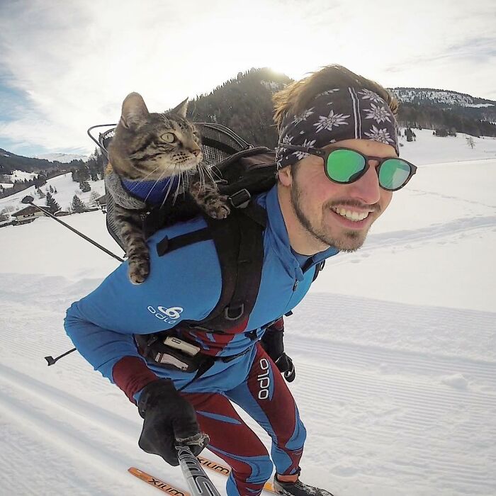 Homem com gato nas costas, durante ski