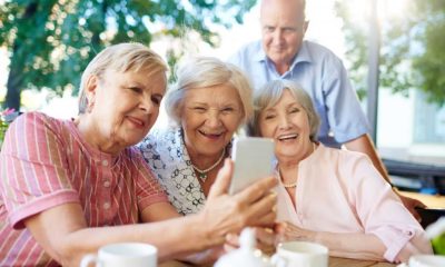 Quatro idosos olhando para celular