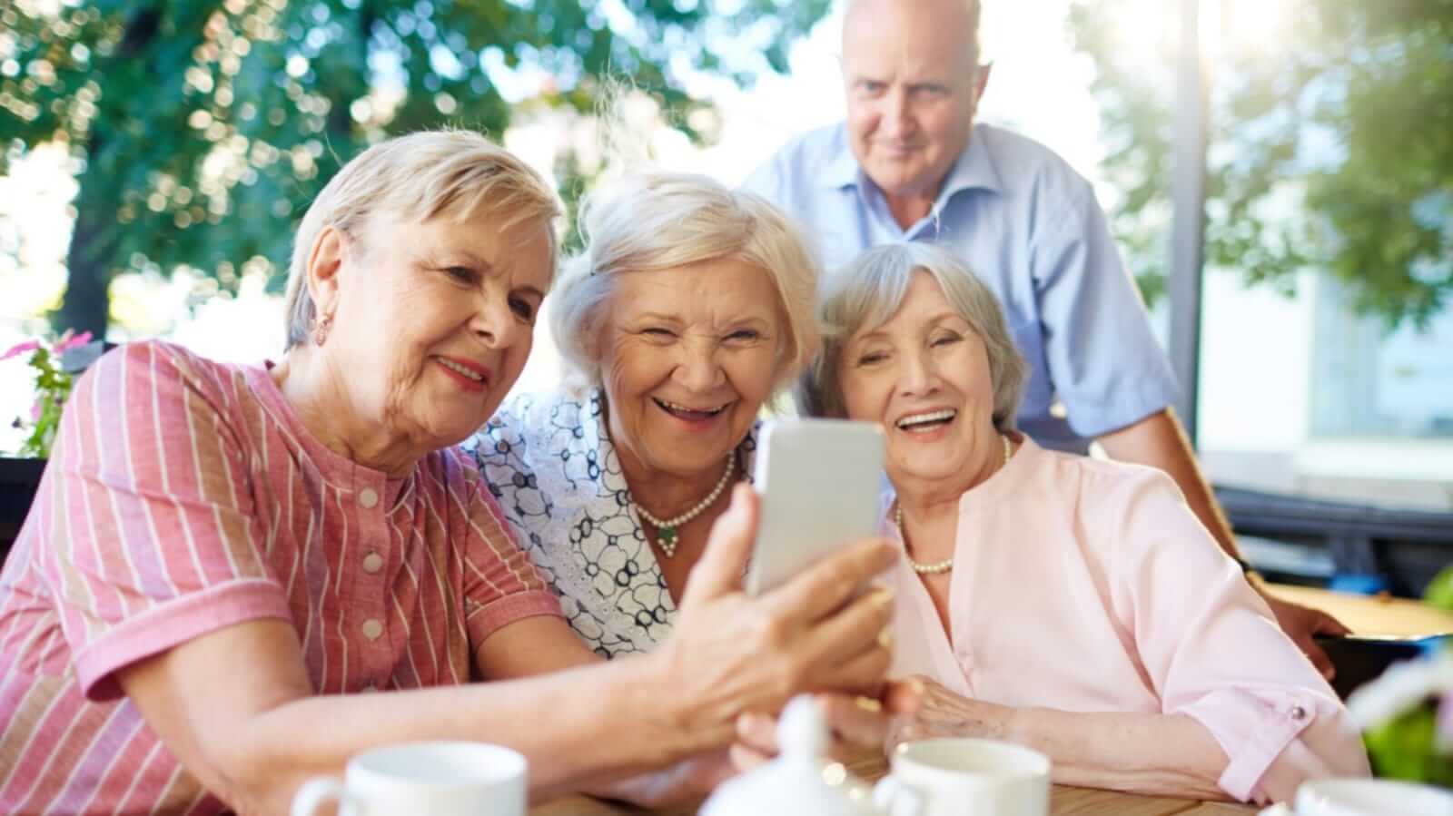 Quatro idosos olhando para celular