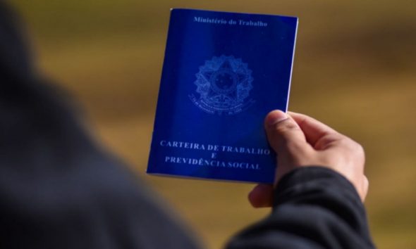 Pessoa com carteira de trabalho na mão