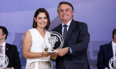 Michelle e Jair Bolsonaro com prêmio nas mãos