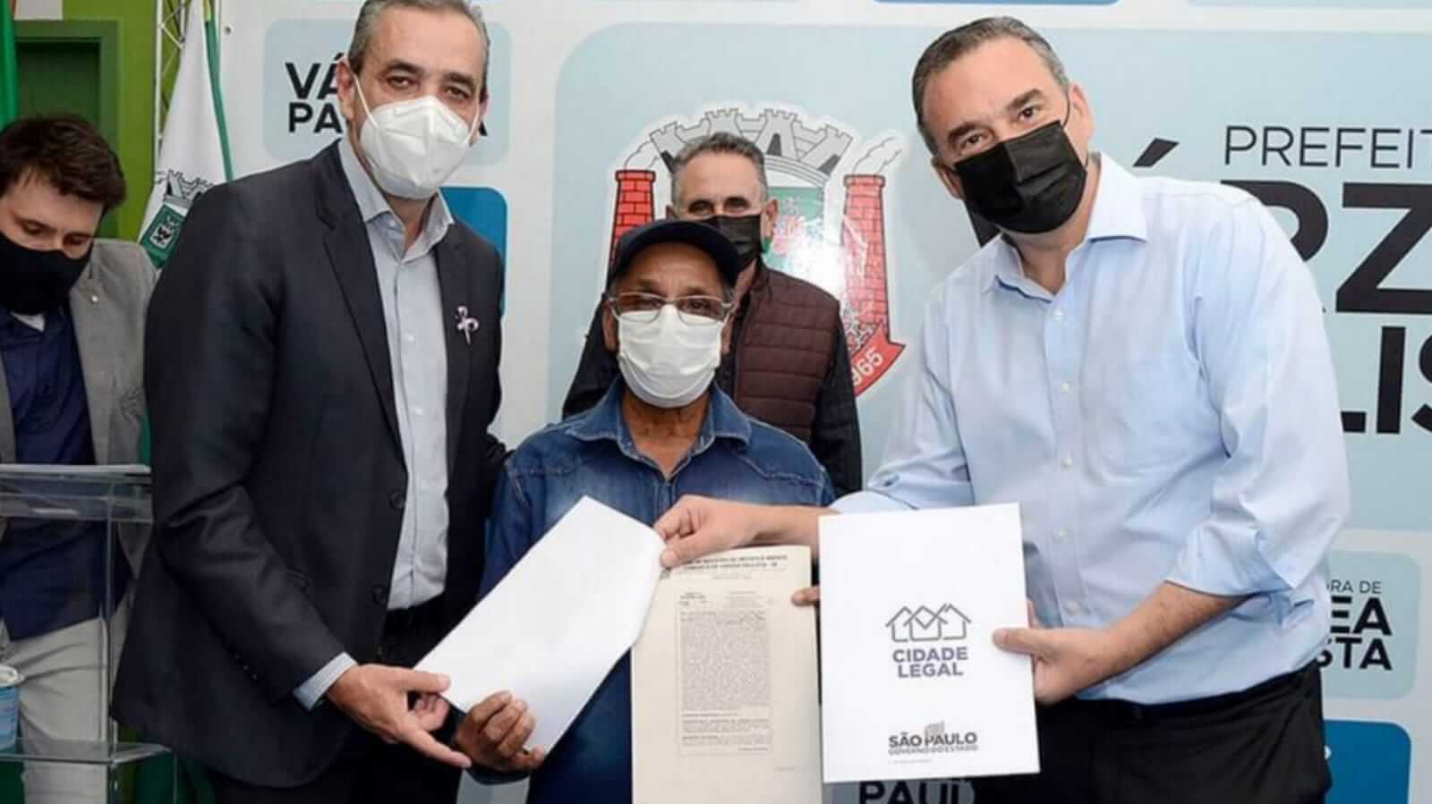 Prefeito de Várzea Paulista entregando documento para morador