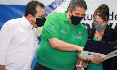 Prefeito e vice-prefeito de Itupeva mostram documento para moradora