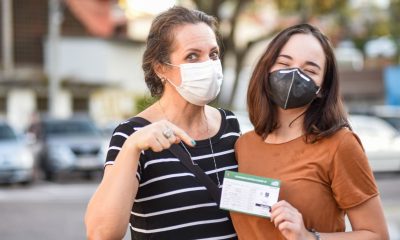 Mulher e menina com cartão de vacinação