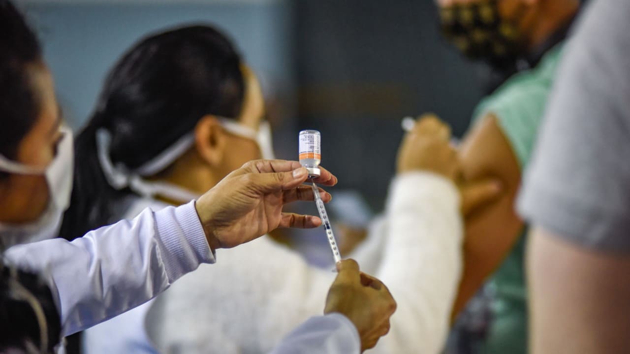Profissionais da saúde administrando seringas de vacina