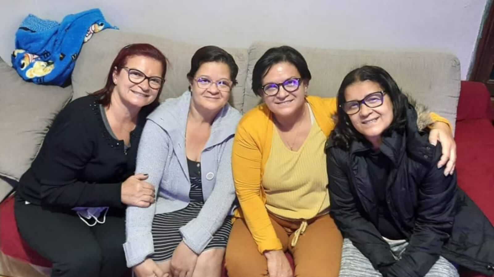 Quatro mulheres sentadas em sofá
