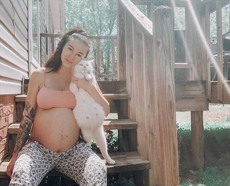Mulher e gata grávidas em escada