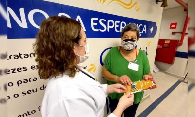 Sra. Maria recebe o manual da enfermeira Flávia