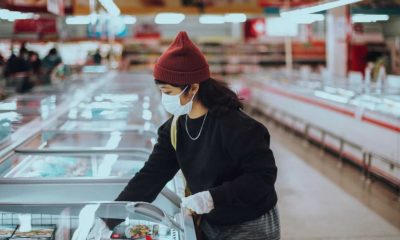 Mulher em supermercado com máscara