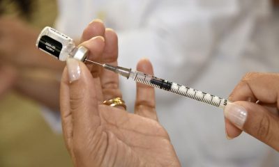 Pessoa administrando seringa de vacina