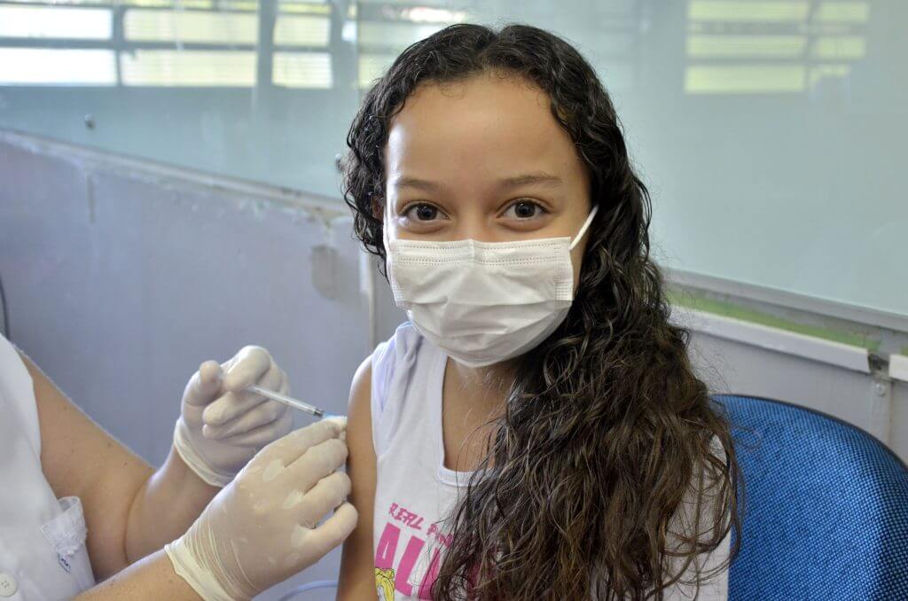 Menina tomando vacina contra covid19