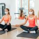 Mulheres de máscara praticando yoga