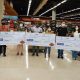 Representantes de entidades sociais, Tauste e Rotary Club Jundiaí segurando cheques gigantes