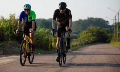 Dois homens em duas bicicletas em uma rodovia