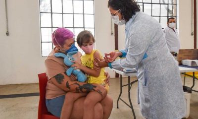 Menina sendo vacinada com ursinho de pelúcia