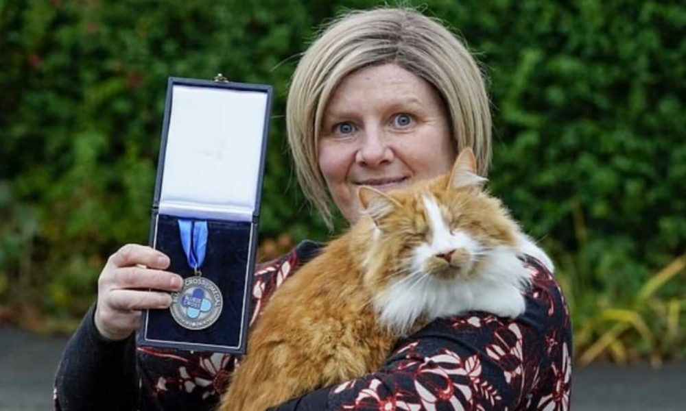 Mulher segurando gato e medalha