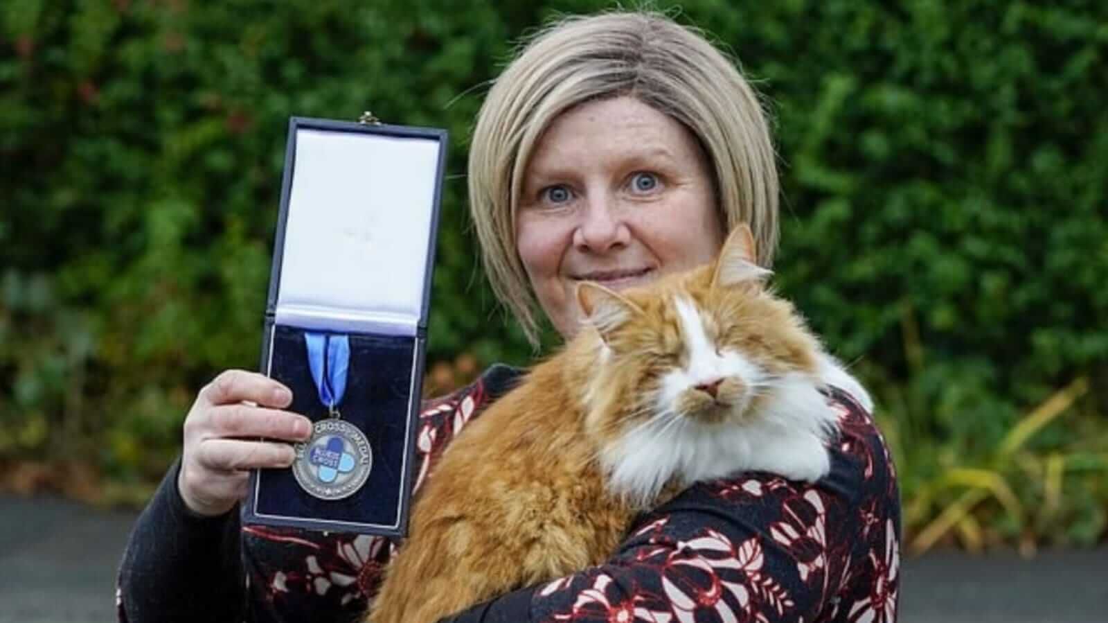 Mulher segurando gato e medalha