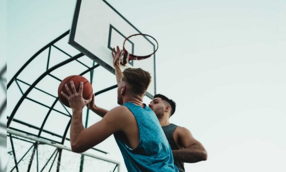 Dois jovens disputando a bola em um jogo de basquete