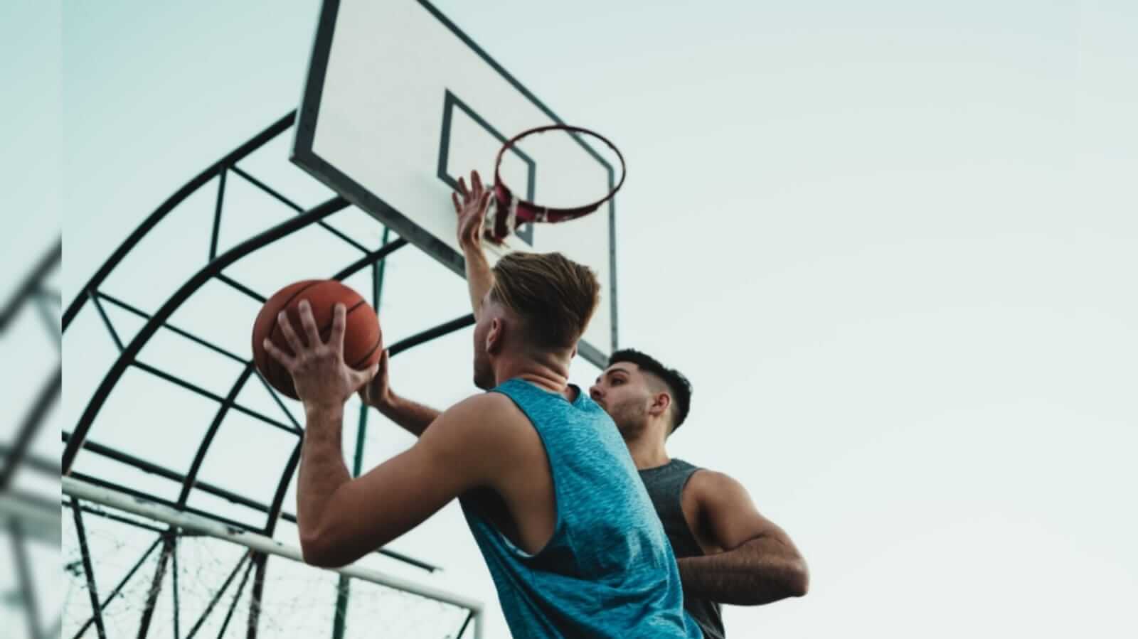 Dois jovens disputando a bola em um jogo de basquete
