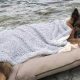 Cachorro deitado em colchão em frente ao mar