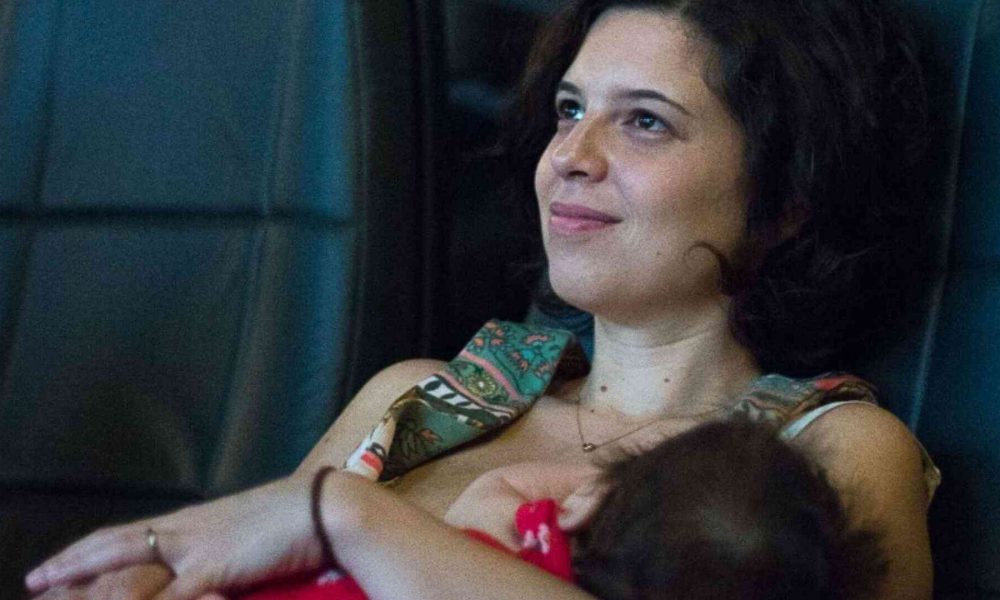 Mãe com bebê no colo no cinema